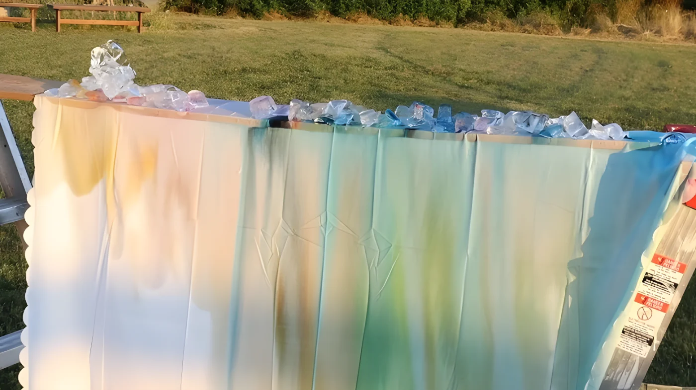 A colored curtain on a wood plank with ice and dyes on top