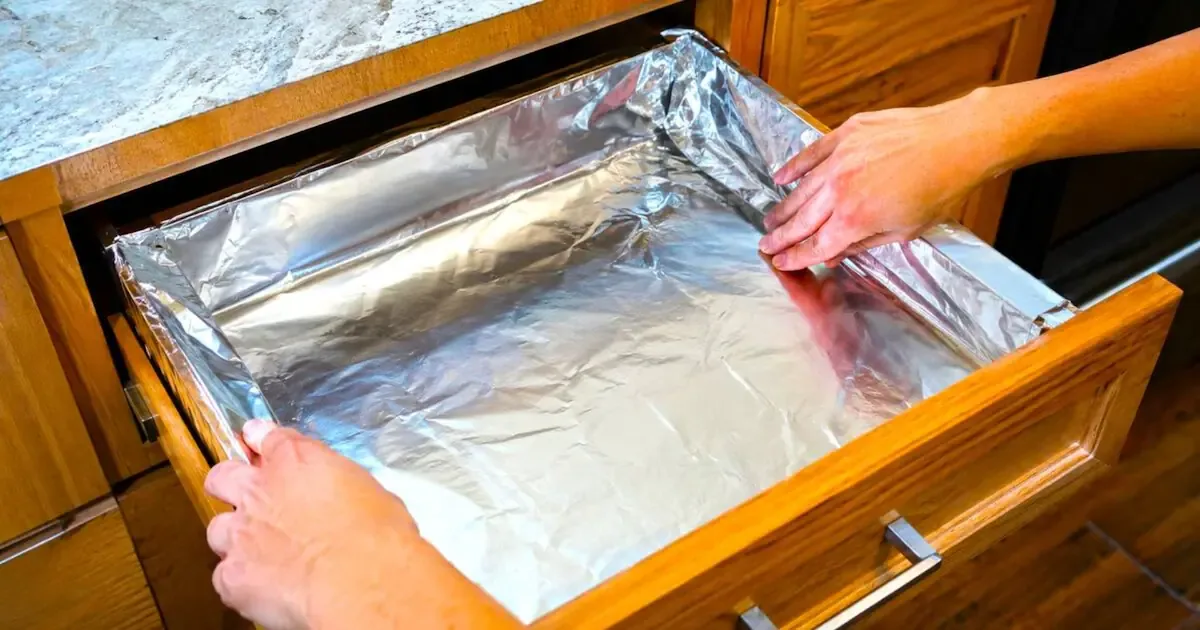 Aluminiumfolie in je keukenla: waarom deze simpele truc uren boenen bespaart