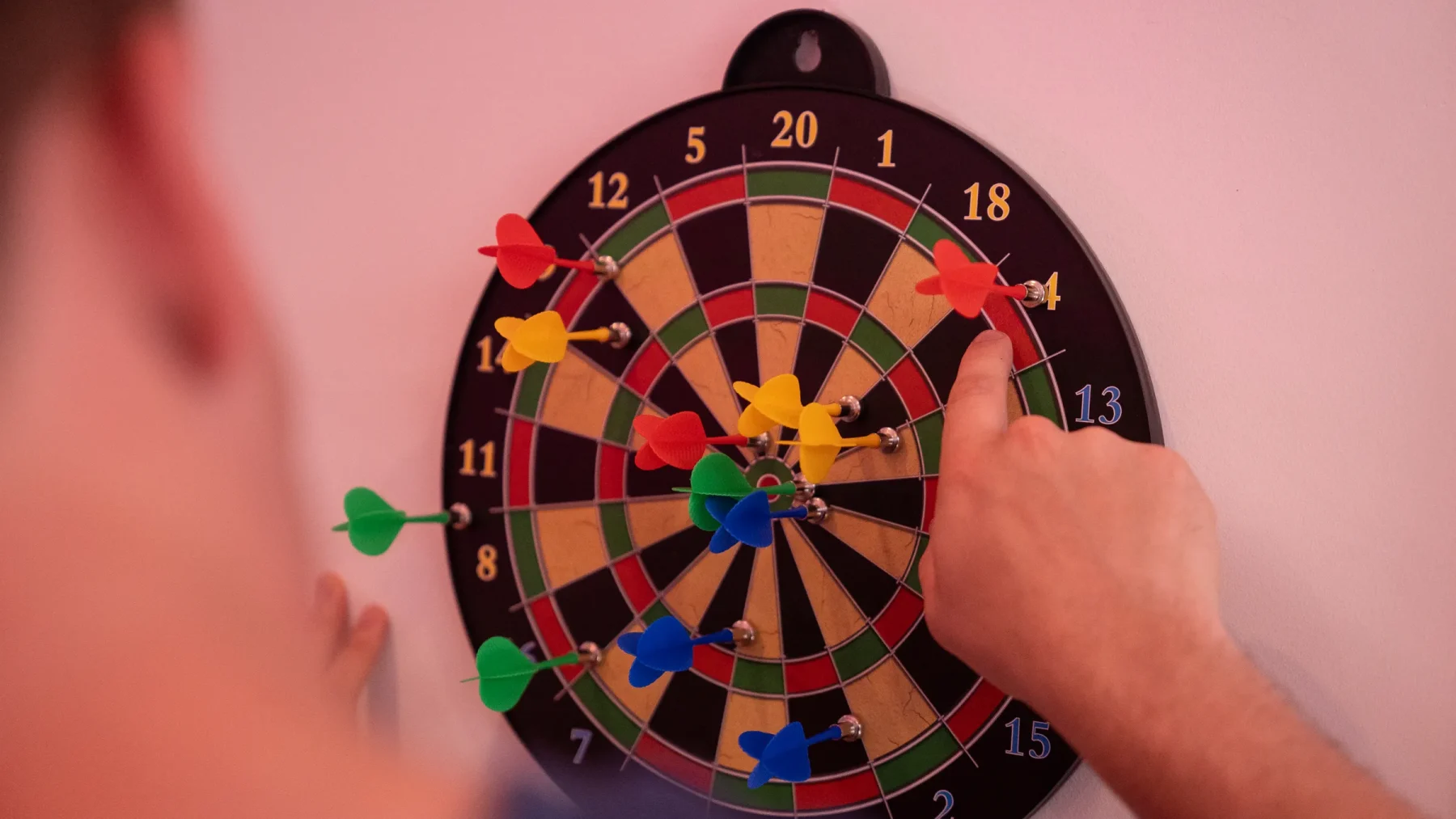 Darter Luke Littler werpt geconcentreerd een dartpijl richting het bord