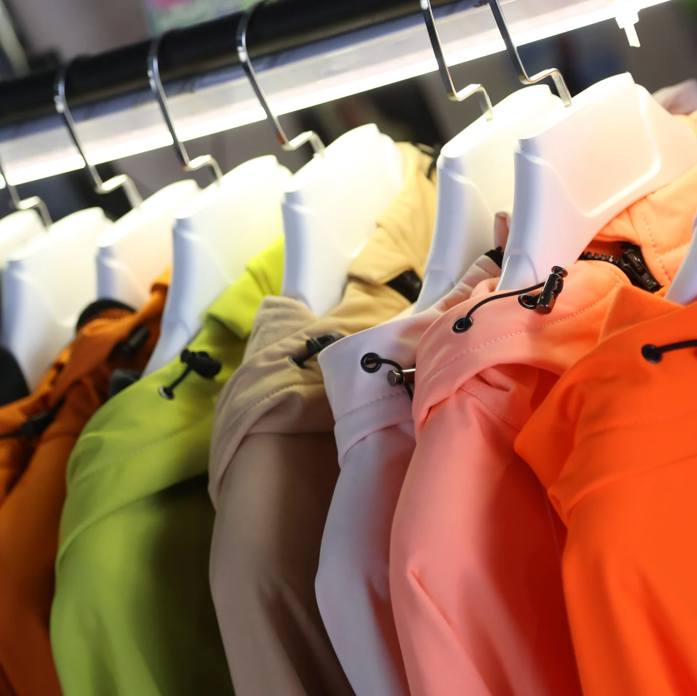 Neon Colored Windbreakers Hanging On Clothing Racks At Local Clothing Market